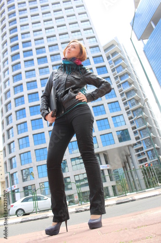 Photo: Beautiful red head posing with a laptop at the city Beautiful red head posing with a laptop at the city