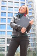 Beautiful redhead woman holding a laptop, at the street