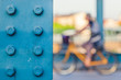 Metal Bridge Pole wtih a Girl Riding a Bicycle in the Background