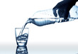 Hand pouring water from plastic bottle into a glass