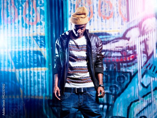 Photo: urban african american in front of graffiti wall urban african american in front of graffiti wall