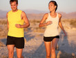 Fitness couple running jogging outside laughing