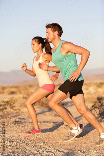 Photo: Runners couple running in trail run outside Runners couple running in trail run outside