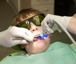 Boy in dental office during hardening of dental filling