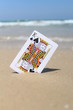 King of clubs card, at the beach