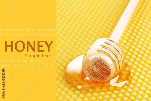 Photo: Yellow beautiful honeycomb and wooden honey dipper with honey . Yellow beautiful honeycomb and wooden honey dipper with honey .