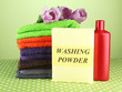 Pile of colorful towels, wash powder and bottle of conditioner