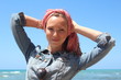 Beautiful redhead woman with scarf, having fun at the beach