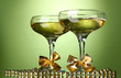 Two glasses of champagne on bright background with lights