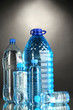 Photo: Different water bottles on grey background Different water bottles on grey background