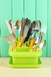 Knives, spoons, forks in plastic container for drying,