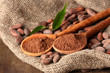 Photo: Cocoa powder in spoons and cocoa beans on wooden background Cocoa powder in spoons and cocoa beans on wooden background