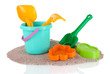 Children's toys on sand isolated on white