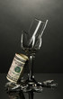 Broken wineglass and money on grey background