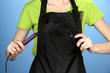 Hairdresser in uniform with working tools, on color background