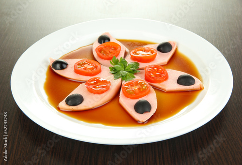 Photo: Small portion of food on big plate on wooden table Small portion of food on big plate on wooden table