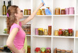 Young housewife cleaning up kitchen on grey background