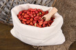Peanuts in sack on wooden background
