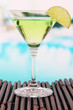 Photo: Green cocktail with lime on table on bright background Green cocktail with lime on table on bright background
