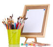 Small easel with sheet of paper with art supplies isolated