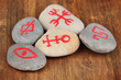 Fortune telling  with symbols on stones on wooden background