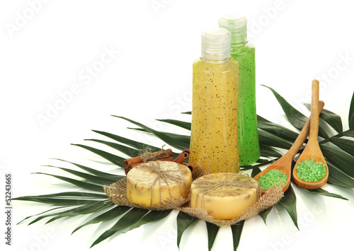 Photo: Bottles with scrub and hand-made soap, isolated on white Bottles with scrub and hand-made soap, isolated on white