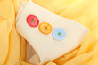 Three buttons on beige and yellow cloth