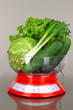 Fresh vegetables in scales on gray background