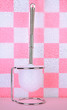 Toilet brush on tile wall background