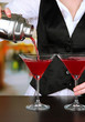 Barmen hand with shaker  pouring cocktail into glasses,