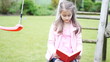 Little girl reading a book in summer