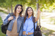 Mixed Race Twin Sisters Wearing Backpacks and Pointing Outside