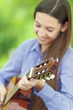 Smiling teenage girl playing guitar