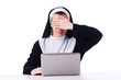 Nun working on laptop - religious concept