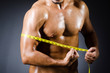 Muscular man measuring his muscles