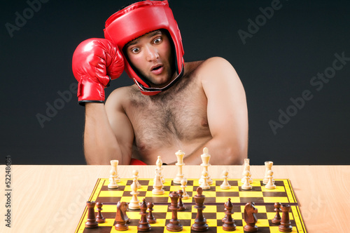 Photo: Boxer stuggling with chess game Boxer stuggling with chess game