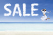 Photo: Girl jumping and sale cloud on white sand beach Girl jumping and sale cloud on white sand beach