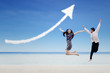 Photo: Happy partners jump under increase arrow sign cloud at beach Happy partners jump under increase arrow sign cloud at beach