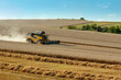 Yellow harvester combine on field harvesting gold wheat