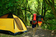 yellow tent and tourists with backpacks