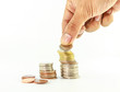 Stack of coins with hand on