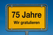 Ortsschild mit blauem Himmel 75 JAHRE WIR GRATULIEREN