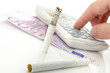Half burned cigarette with calculator and Euro money