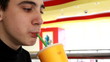 Portrait of happy little boy drinking orange juice.