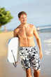Photo: Man on beach holding body surfing bodyboard Man on beach holding body surfing bodyboard