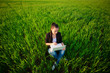 happy girl in a green field with a laptop. summer