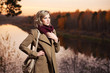 Foto: Young blond woman against an autumn nature background Young blond woman against an autumn nature background