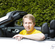 Mature man with arms on top of convertible car door