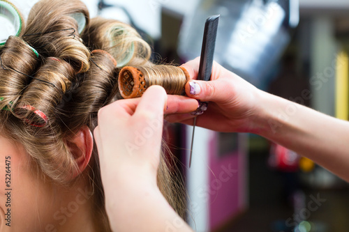 Photo: Woman at the hairdresser curling hair Woman at the hairdresser curling hair