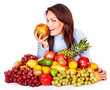 Girl with group of fruit and vegetables.